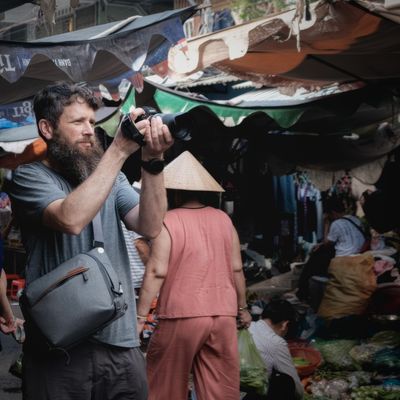 Clancy photographing at a bustling market in Vietnam.